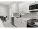 Eat-in kitchen featuring white cabinets, stainless steel appliances, and grey subway tile backsplash at 2186 Florala St, North Port, FL 34287