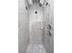 Stylish walk-in shower featuring sleek fixtures, gray tiling, decorative accent tiles, and pebble flooring at 2186 Florala St, North Port, FL 34287