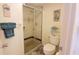 Well-lit bathroom featuring glass shower, toilet, and decorative artwork at 2275 S Mccall Rd # 103, Englewood, FL 34224