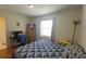 Bedroom with a patterned comforter, side table and closet space at 2275 S Mccall Rd # 103, Englewood, FL 34224
