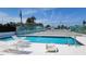 Relaxing poolside scene with lounge chairs, showcasing a clear blue pool and tennis court in the background at 2275 S Mccall Rd # 103, Englewood, FL 34224