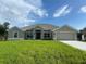 Charming single-story home with neutral paint, manicured lawn, and an attached two-car garage at 23245 Jules Ave, Port Charlotte, FL 33980