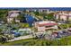 Panoramic aerial view of a waterfront condo community featuring a pool, tennis court, and boat docks at 25188 Marion Ave # 10, Punta Gorda, FL 33950