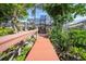 Scenic backyard featuring a wooden boardwalk leading to a screened-in lanai surrounded by lush landscaping at 25188 Marion Ave # 10, Punta Gorda, FL 33950