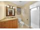 Bathroom with wood vanity, framed mirror, toilet, and shower with glass doors at 25188 Marion Ave # 10, Punta Gorda, FL 33950