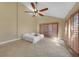 Bright bedroom with large window shutters, tile flooring, and a modern ceiling fan at 25188 Marion Ave # 10, Punta Gorda, FL 33950