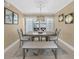 Dining room with beach artwork, chair rail, modern chandelier, and bench seating at 25188 Marion Ave # 10, Punta Gorda, FL 33950