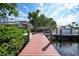 Waterfront scene with a wooden dock, boat lift, and lush vegetation in a serene setting at 25188 Marion Ave # 10, Punta Gorda, FL 33950