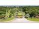 View of the entrance to Emerald Pointe, featuring beautiful landscaping and palm trees lining the driveway at 25188 Marion Ave # 10, Punta Gorda, FL 33950