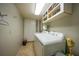 Well-lit laundry area with washer, dryer, storage cabinets, and tile flooring at 25188 Marion Ave # 10, Punta Gorda, FL 33950