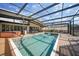 Backyard pool with a hot tub, outdoor dining, and surrounded by an enclosure at 25188 Marion Ave # 10, Punta Gorda, FL 33950
