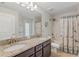 Bathroom with dual sink granite vanity, decorative shower curtain, and ample lighting, providing a luxurious feel at 27147 Guapore Dr, Punta Gorda, FL 33983
