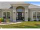 Close up of the front door featuring large arched windows and decorative plants at 27147 Guapore Dr, Punta Gorda, FL 33983