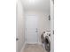 Well-lit laundry room featuring a washer and dryer set, door, and tile flooring at 27147 Guapore Dr, Punta Gorda, FL 33983