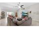 Bright living room featuring neutral colors, tiled floors, ceiling fan, and sliding glass door at 27147 Guapore Dr, Punta Gorda, FL 33983