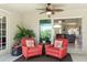 Relaxing screened patio showcases red chairs, potted plants, and a ceiling fan, creating an inviting outdoor space at 27147 Guapore Dr, Punta Gorda, FL 33983