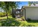 Backyard with screened-in lanai, lush grass, and mature trees for privacy at 27147 Guapore Dr, Punta Gorda, FL 33983