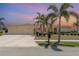 Charming single-story home featuring mature palm trees, a two-car garage, and a well-manicured lawn at 283 Fields Se Ter, Port Charlotte, FL 33952