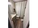 Bright bathroom featuring a vanity, framed mirror, shower with white curtain, and wood-look flooring at 376 Waterside St, Port Charlotte, FL 33954
