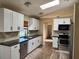 Bright kitchen with stainless steel appliances, black counters, and white cabinets under a skylight at 376 Waterside St, Port Charlotte, FL 33954