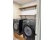 Laundry room featuring black Samsung washer and dryer with mounted wooden shelves at 376 Waterside St, Port Charlotte, FL 33954
