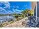 Waterfront backyard with a boat lift, lush landscaping, and a brick paved patio with seating at 3866 Turtle Dove Blvd, Punta Gorda, FL 33950