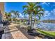 Picturesque waterfront backyard with boat lift, well-manicured landscaping, and brick patio at 3866 Turtle Dove Blvd, Punta Gorda, FL 33950