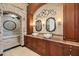This stylish bathroom features dual vessel sinks, stone accents, and a luxurious tub beneath an arched entryway at 3866 Turtle Dove Blvd, Punta Gorda, FL 33950