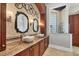 This bathroom boasts dual vessel sinks with stone backsplash, framed mirrors, and a glass enclosed shower at 3866 Turtle Dove Blvd, Punta Gorda, FL 33950