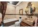 A rustic bathroom features a stone sink, soaking tub, and travertine walls for a relaxing and unique space at 3866 Turtle Dove Blvd, Punta Gorda, FL 33950