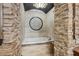A luxurious bathtub sits beneath a stone archway with a decorative medallion for a relaxing spa atmosphere at 3866 Turtle Dove Blvd, Punta Gorda, FL 33950