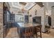 Gourmet kitchen with stone accent wall, custom dark wood cabinets, granite island, and premium appliances at 3866 Turtle Dove Blvd, Punta Gorda, FL 33950
