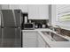 Modern kitchenette featuring stainless steel appliances, white cabinets, and a sink by the window at 3866 Turtle Dove Blvd, Punta Gorda, FL 33950