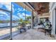 Screened lanai featuring comfortable seating, a ceiling fan, and scenic waterfront views at 3866 Turtle Dove Blvd, Punta Gorda, FL 33950