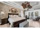 Main bedroom features stone wall accents, tray ceiling, fan, luxurious bed and comfortable seating at 3866 Turtle Dove Blvd, Punta Gorda, FL 33950