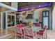 Outdoor kitchen and dining area with stainless steel appliances, a stone wall, ceiling fan and chandelier at 3866 Turtle Dove Blvd, Punta Gorda, FL 33950