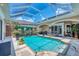 Enclosed pool with spa, waterfall feature, landscaped surround and shaded patio area for relaxing at 3866 Turtle Dove Blvd, Punta Gorda, FL 33950