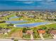 Aerial view of the beautiful home with a tile roof and a well-manicured front yard, surrounded by lush landscaping at 4015 La Costa Island Ct, Punta Gorda, FL 33950