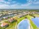 Aerial view showcasing the house nestled on a golf course with a serene pond, surrounded by lush landscaping and mature trees at 4015 La Costa Island Ct, Punta Gorda, FL 33950