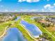 Stunning aerial view of a golf course community with multiple ponds and homes with lush landscaping and mature trees at 4015 La Costa Island Ct, Punta Gorda, FL 33950