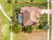 Aerial view of a single Gathering home with tile roof, screened-in pool, driveway and tropical landscaping at 4015 La Costa Island Ct, Punta Gorda, FL 33950
