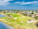 Stunning aerial shot of a golf course community, featuring lush green fairways, sand traps, and waterways at 4015 La Costa Island Ct, Punta Gorda, FL 33950