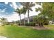 Expansive backyard featuring a screened lanai and lush landscaping with mature palm trees at 4015 La Costa Island Ct, Punta Gorda, FL 33950