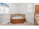 Well-lit bathroom boasts a tub with wood paneling and tile, plus a double sink vanity with granite counters at 4015 La Costa Island Ct, Punta Gorda, FL 33950