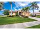 Inviting home featuring lush landscaping, mature palm trees, and a well-maintained lawn at 4015 La Costa Island Ct, Punta Gorda, FL 33950