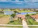 Inviting home featuring a tile roof, mature palm trees, and lush green lawn, perfectly situated on a picturesque golf course at 4015 La Costa Island Ct, Punta Gorda, FL 33950