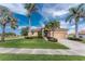 Charming single-story home featuring a lush green lawn, tropical landscaping, and a double-door entrance at 4015 La Costa Island Ct, Punta Gorda, FL 33950