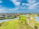 Scenic aerial view of a golf course with surrounding homes, lush greens, palm trees, and tranquil water features at 4015 La Costa Island Ct, Punta Gorda, FL 33950