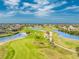 Scenic aerial view of a lush golf course with winding paths, palm trees, and serene blue water features under a blue sky at 4015 La Costa Island Ct, Punta Gorda, FL 33950