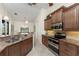 Spacious kitchen with stainless steel appliances and granite countertops offering a view to the lanai and lake at 4015 La Costa Island Ct, Punta Gorda, FL 33950